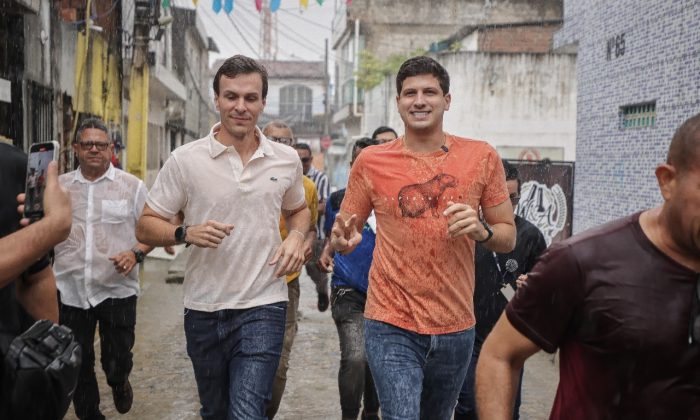 Correndo na chuva: Miguel Coelho e João Campos, em inauguração de obras no bairro do Torrões, em Recife (Foto: Edson  Holanda/Prefeitura do Recife)